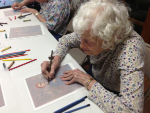 A senior woman draws a picture